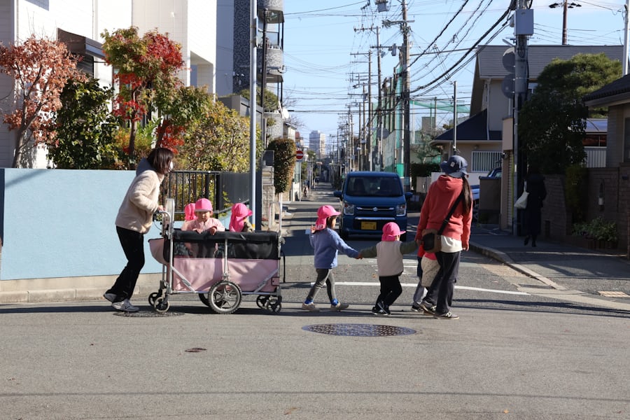 子ども達と先生が道路を歩いている様子