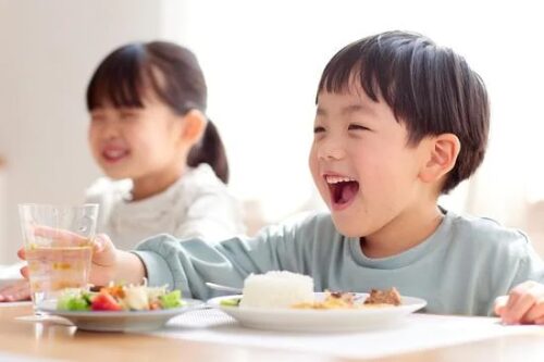 笑顔で食事する子どもたち