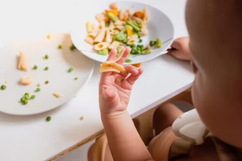 机の上の食べ物を、手に取って眺めている