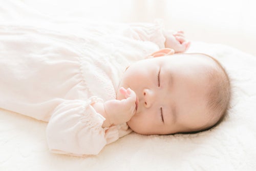 赤ちゃんが指を咥えて寝ている