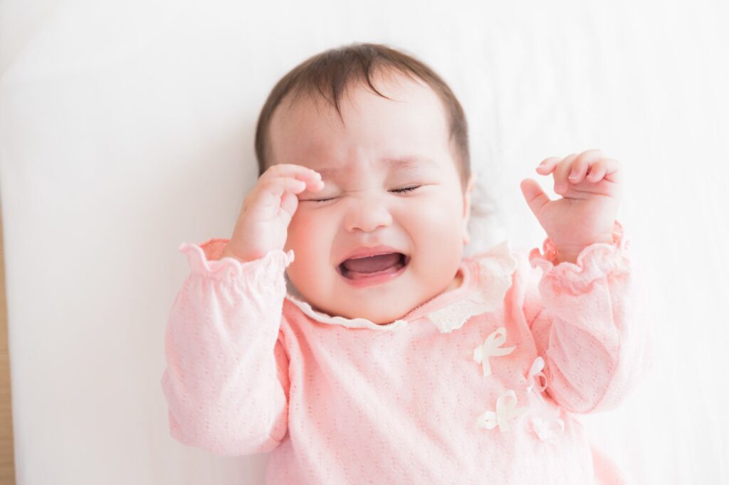 ピンク色の服を着た泣いている小さな子ども