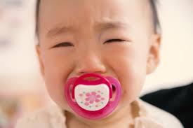 おしゃぶりを咥えている小さな子ども