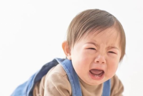 はいはいしながら、泣いている小さな子ども
